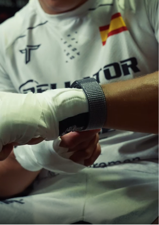 Person wearing a white boxing glove and a watch with a blurred background